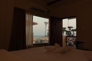 1 dormitorio con cama y vistas al océano en PALM PARADISE Beach Resort en Pondicherry