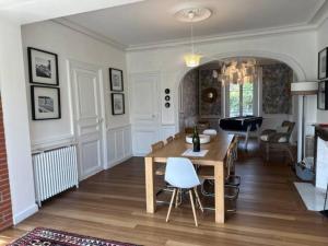 - un salon avec une table et des chaises en bois dans l'établissement Villa Les Myosotis, à Dinard