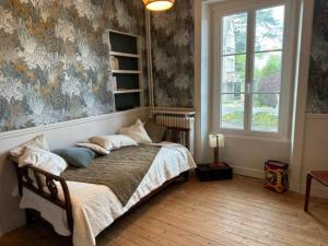 - une chambre avec un lit et une fresque murale dans l'établissement Villa Les Myosotis, à Dinard