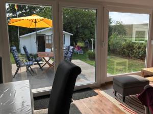 布特亚丁根E3 Haus mit Wintergarten, Kamin und Deichblick的带桌椅和遮阳伞的露台 更多14张照片