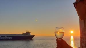 a person holding a glass of wine in front of a ship at Wohnung in Vlissingen mit Terrasse und Meerblick in Vlissingen