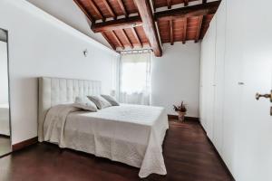 a bedroom with a white bed and a window at Villa Belcanto Mugello - Affitti Brevi Italia in Vicchio