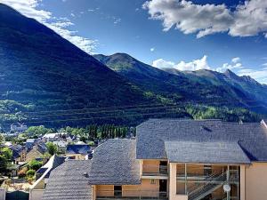 une maison avec une montagne en arrière-plan dans l'établissement Résidence Pyrénées Zenith, à Luz-Saint-Sauveur