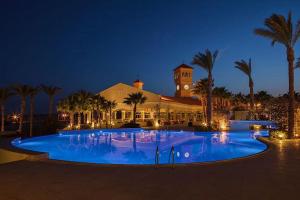 duży basen przed budynkiem z palmami w obiekcie Stunning Pool View 1bed Private Beach Clubs, Veranda Sahl Hasheesh w mieście Hurghada