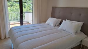 - une chambre avec un grand lit blanc et une fenêtre dans l'établissement La Torre del Paraiso, à Malaga