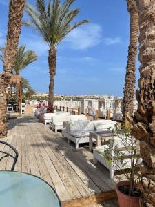 un patio con palmeras, mesas y sillas en Stunning Pool View 1bed Private Beach Clubs, Veranda Sahl Hasheesh, en Hurghada