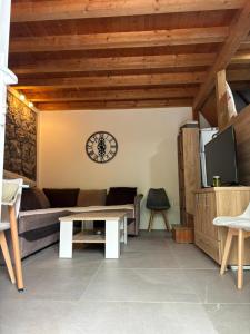 salon z kanapą i zegarem na ścianie w obiekcie Bay House Kakrc w mieście Tivat