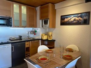 a kitchen with a wooden table with chairs and a sink at Appartement cozy aux Gets - Ski-in/Ski-out, proche centre et commodités - FR-1-623-214 in Les Gets