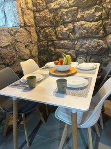 a white table with a bowl of fruit on it at Bay House Kakrc in Tivat
