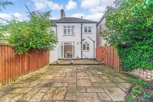 una vista exterior de una casa blanca con una valla en Pass the Keys Spacious Family Home in London, en Londres