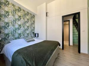 a bedroom with a large bed with a floral wallpaper at L'Atelier Saint-Martin by Melrose in Saint-Martin-des-Entrées