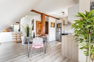 a kitchen and dining room with a table and chairs at Les Glycines du Sommerberg in Niedermorschwihr