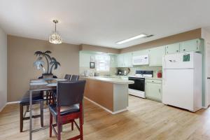 a kitchen with a table and a white refrigerator at Beach & Chill in South Padre Island