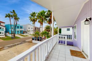 a balcony of a house with palm trees at Beach & Chill in South Padre Island