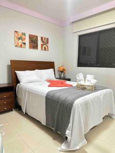 ein Schlafzimmer mit einem Bett mit einer weißen Decke und einem Fenster in der Unterkunft Apt encantador! Perto da orla e C de Convenções- Apartamento inteiro in Salvador