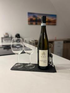 butelkę wina i dwa kieliszki wina na blacie w obiekcie Reviv - Traumhaftes 3 Zimmer Apartment w mieście Brühl