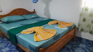 a bedroom with a bed with two towels on it at KANTHI GUEST INN in Trincomalee