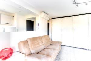 sala de estar con sofá de cuero marrón en Mimosas furnished flat, en Antibes