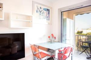 comedor con mesa de cristal y sillas rojas en Mimosas furnished flat, en Antibes