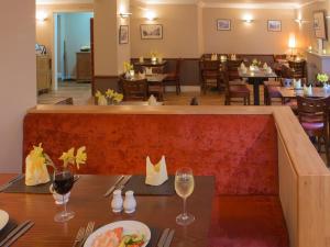 Tigh Na Mara Hotel في Sandhead: غرفة طعام مع طاولة مع كؤوس للنبيذ