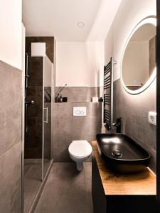 a bathroom with a black sink and a toilet at Si-View Einzelzimmer mit Balkon Zimmer 3 - Hotel in Siegen