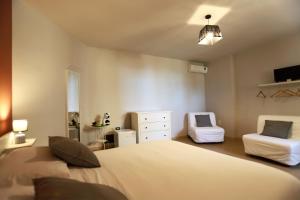 Un dormitorio con 2 camas y una silla. en Le Chiavi, en Erice