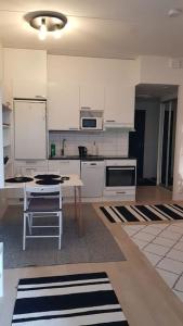 a kitchen with white cabinets and a table at Cozy Studio in Vantaa in Vantaa