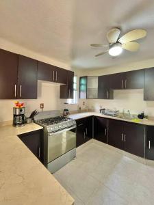 a kitchen with a stove and a ceiling fan at Casa Coccoloba, Chetumal, Quintana Roo in Chetumal