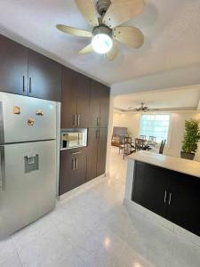 a kitchen with a refrigerator and a ceiling fan at Casa Coccoloba, Chetumal, Quintana Roo in Chetumal