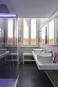 a bathroom with two sinks and two mirrors at Trevi Luxury Terrace in Rome