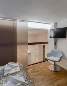 um quarto com uma cama, uma cadeira e uma televisão em Trevi Luxury Terrace em Roma