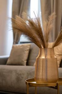 a vase with feathers on a table in front of a couch at Trevi Luxury Terrace in Rome