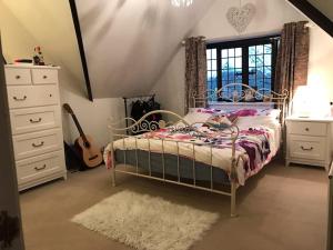 sypialnia z łóżkiem i gitarą w obiekcie Beautiful Stratford-On-Avon House, suits 14 - 15 w mieście Shottery