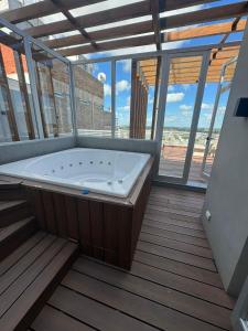 bañera grande en una habitación con ventanas en Dpto temporal amueblado con yacuzzi en San Lorenzo