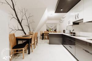 une cuisine avec une table et un arbre sur le mur dans l'établissement Zielony Domek Pokoje z widokiem na góry i sauną, à Kościelisko