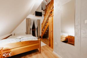 - une chambre avec un lit et un escalier en bois dans l'établissement Zielony Domek Pokoje z widokiem na góry i sauną, à Kościelisko