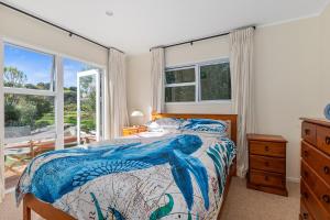 a bedroom with a bed with an octopus bedspread at Teal Bay Treasure - Teal Bay Holiday Home in Whangaruru North