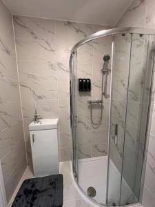 a bathroom with a shower with a toilet and a sink at Vauxhall Victoria moments away in London