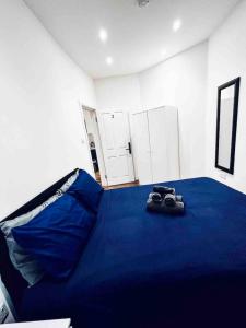 a bedroom with a bed with a blue blanket and a pair of shoes at Central London- Zone 1 - Room 3 in London