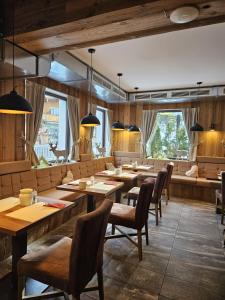 a restaurant with wooden tables and chairs and windows at Hotel Alpennest - Mountain Hideaway in Leutasch in Leutasch