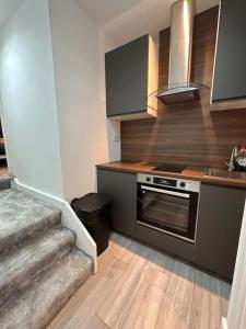 a kitchen with a stove and a sink and a staircase at London Eye 15 minutes away in London