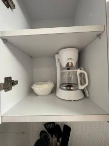 a kitchen cabinet with a coffee maker on a shelf at C&C Studio in San Juan