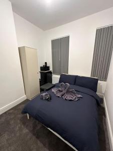 a bedroom with a blue bed with purple clothes on it at Room in Central London Zone 1 in London