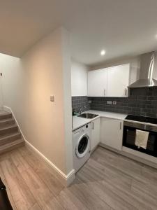 a kitchen with a washer and a washing machine at Room in Central London Zone 1 in London
