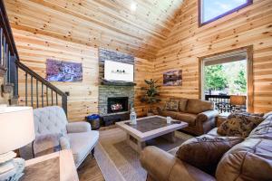 a living room with a fireplace in a log cabin at Stunning Balcony View Frequent Deer Sightings in Broken Bow