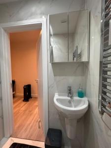 ein weißes Badezimmer mit Waschbecken und Spiegel in der Unterkunft Central London Zone1 Room - Bath in London