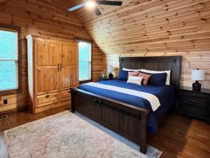 ein Schlafzimmer mit einem Bett in einem Blockhaus in der Unterkunft Stunning Balcony View Frequent Deer Sightings in Broken Bow