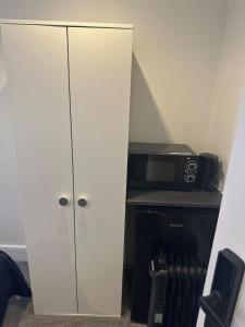 a white cabinet in a room with a microwave at Piccadilly Circus 15minutes away in London