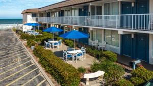 a balcony of a hotel with tables and umbrellas at Fantasy Island Resort, Daytona Beach Shores in Daytona Beach Shores