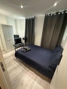 a bedroom with a blue bed in a room at London Waterloo Moments away in London